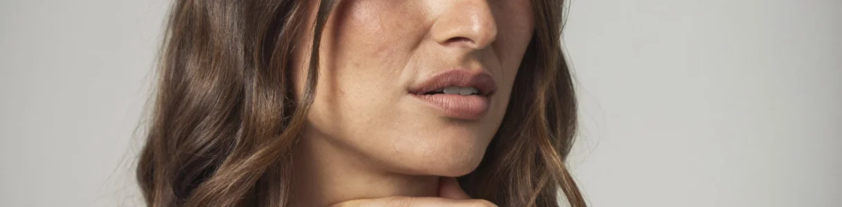Γυναίκα με βράγχος φωνής κρατά τον λαιμό της